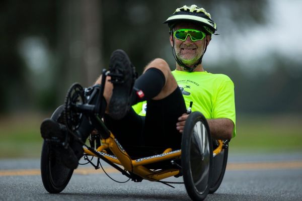 A close-up shot of Dan riding his trike with a confident grin.